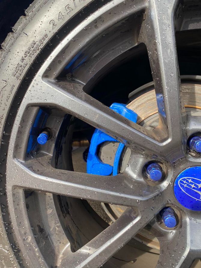 A Close Up of a Car Wheel With Blue Brake Calipers — Savins Radiator Service In Lismore, NSW