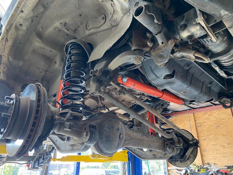 A Close Up of the Underside of a Car on a Lift — Savins Radiator Service In Lismore, NSW