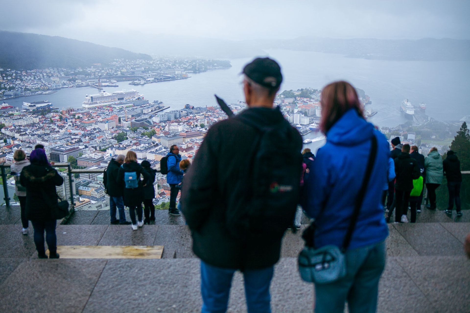 Tour Guide Pointing Out Bergen to Guest from Fløien Mountain