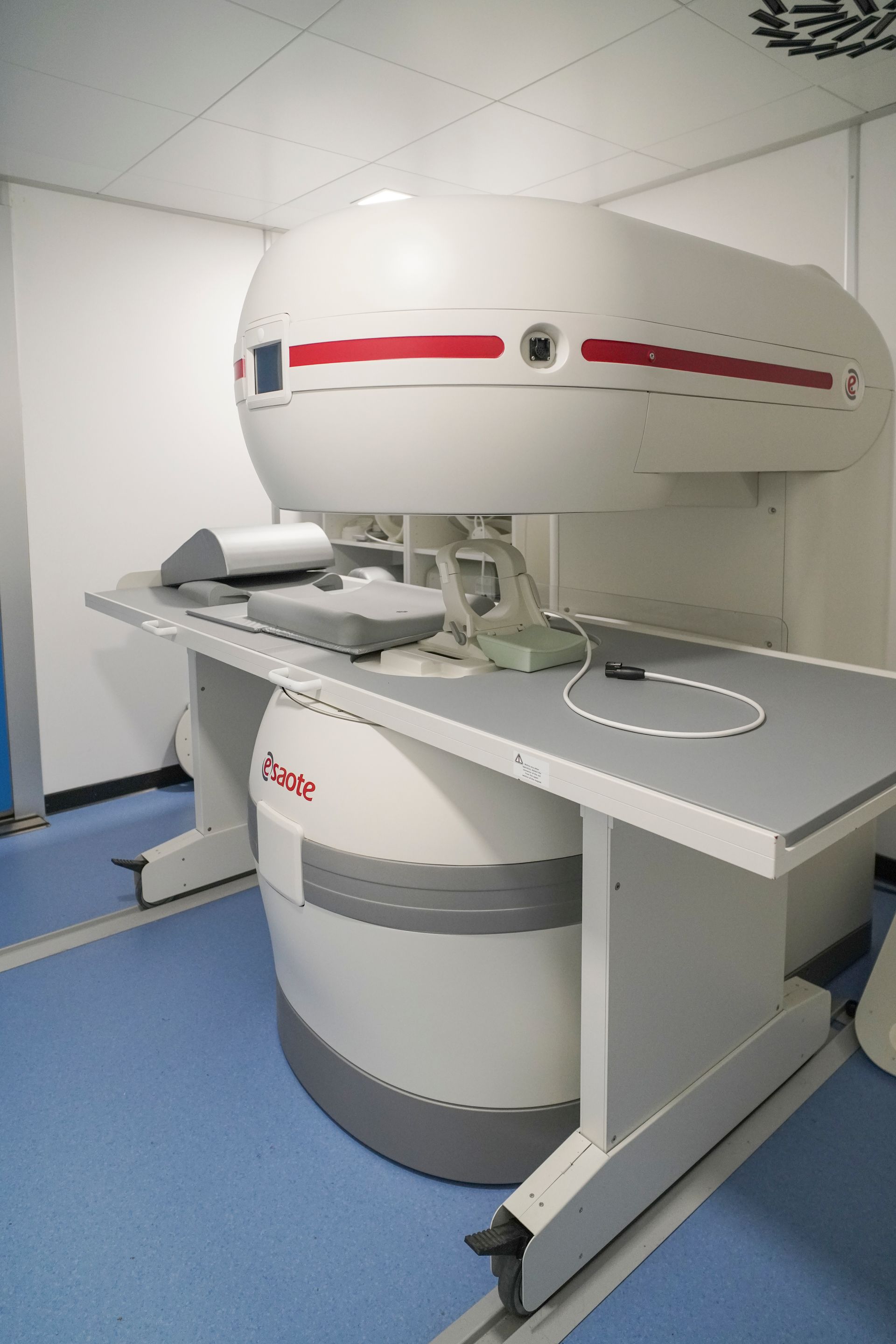 Una macchina per la risonanza magnetica è posizionata sopra un tavolo in una stanza.