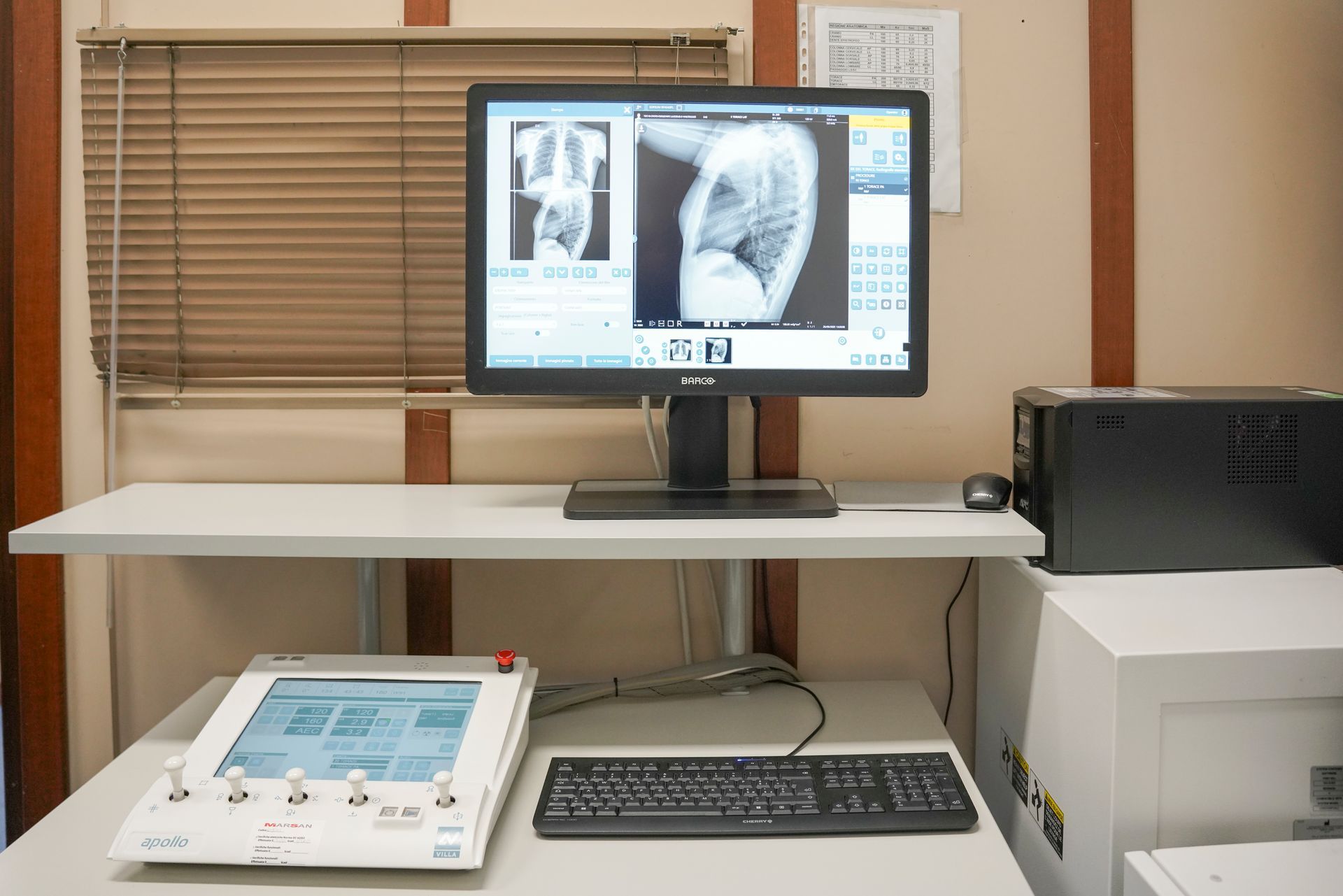 Un monitor di computer è posizionato sopra una scrivania accanto a una tastiera.