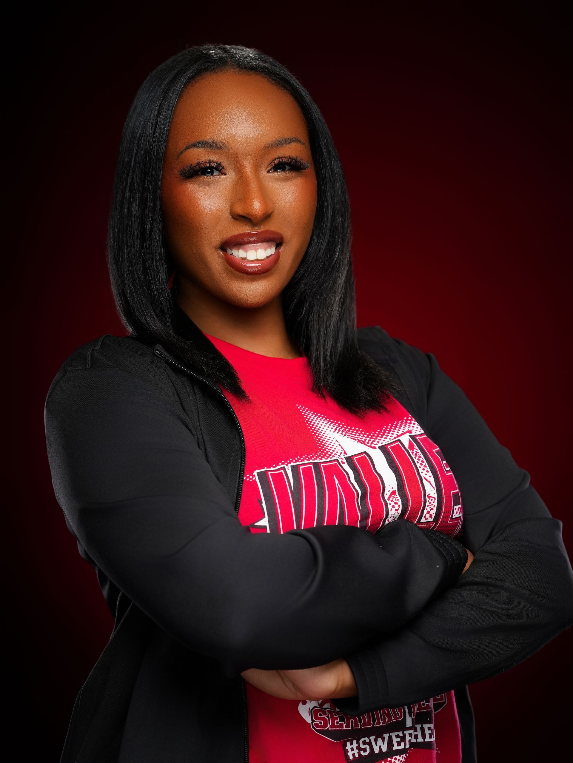 A smiling person with shoulder-length hair