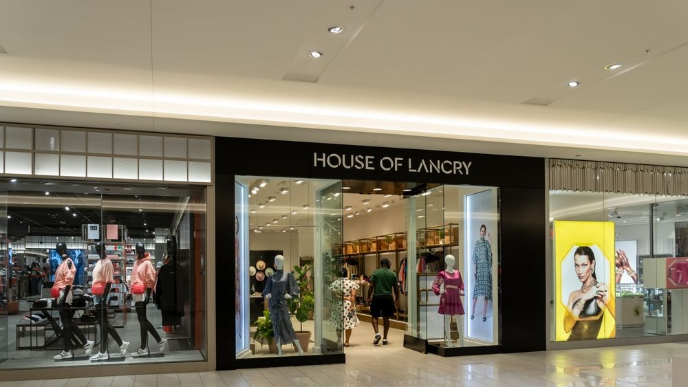 House of Lancry store entrance with glass displays and mannequins. Two people walk in.