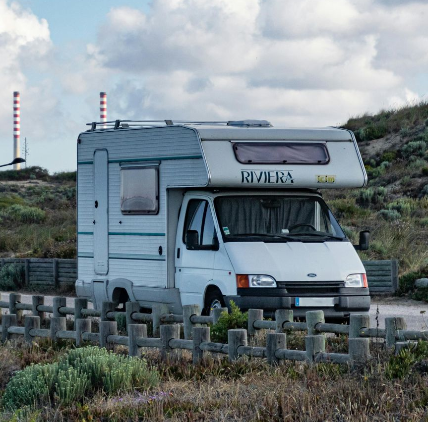 Man working on a sewer; orange gloves, metal pipe, open manhole, ladder, grate.