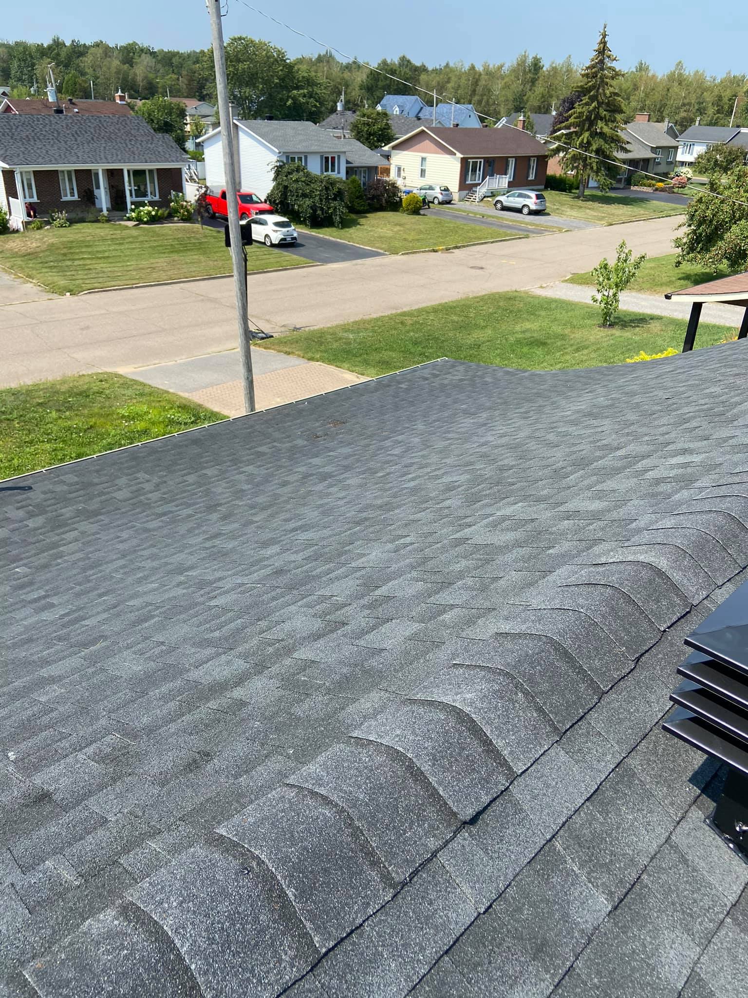 Le toit d'une maison avec une pile de panneaux solaires dessus.