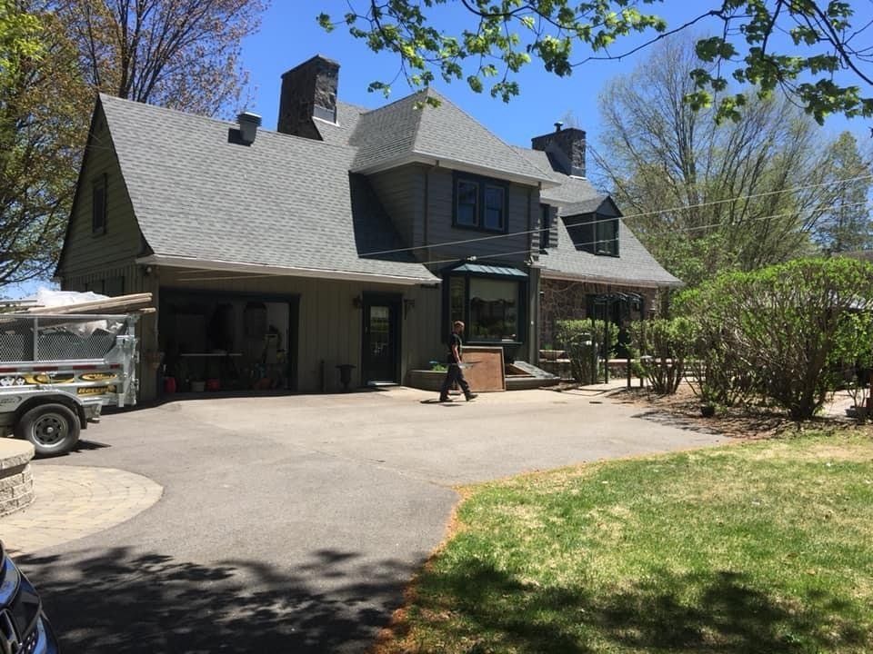 Un homme marche devant une grande maison