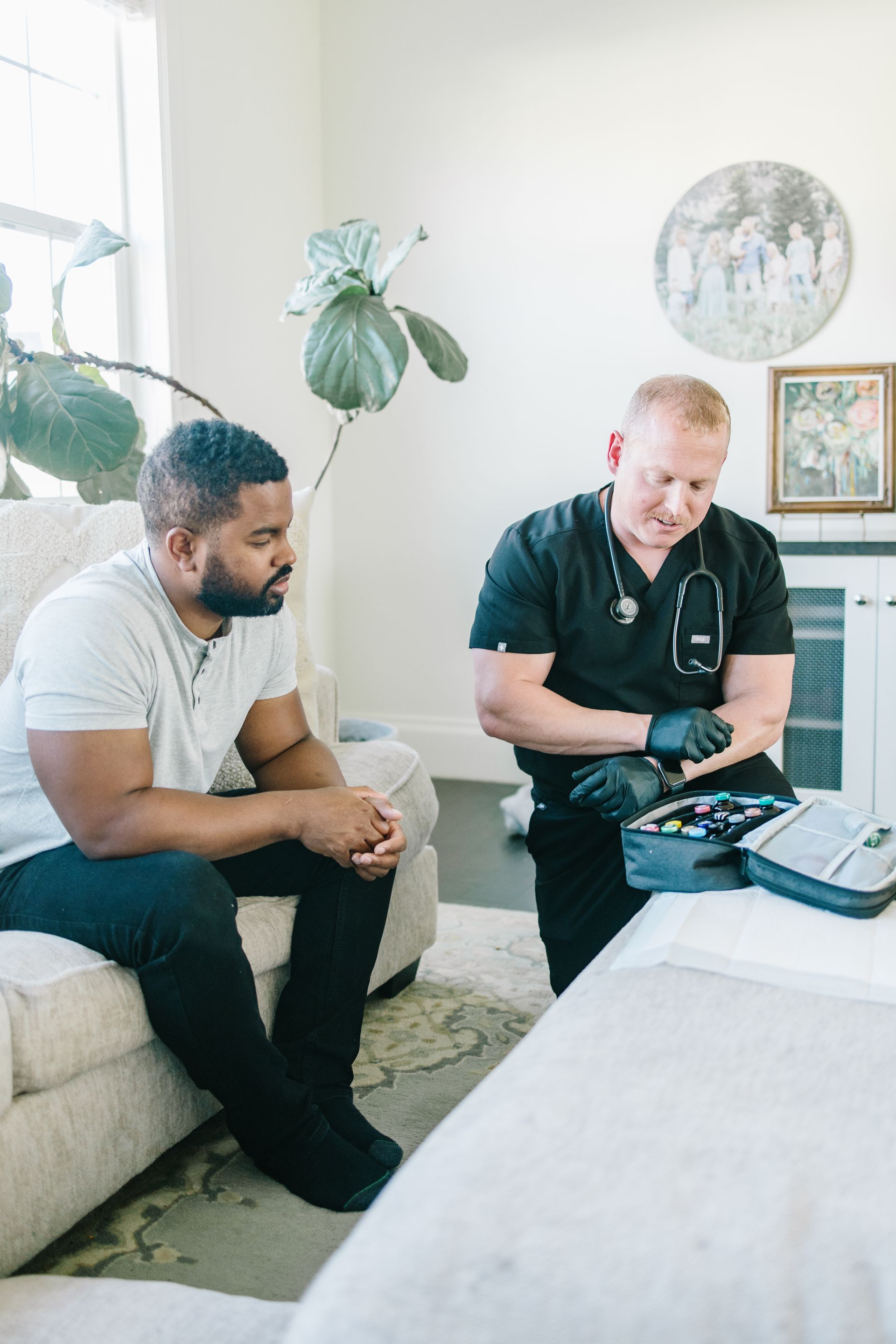A man is sitting on a couch talking to a doctor.