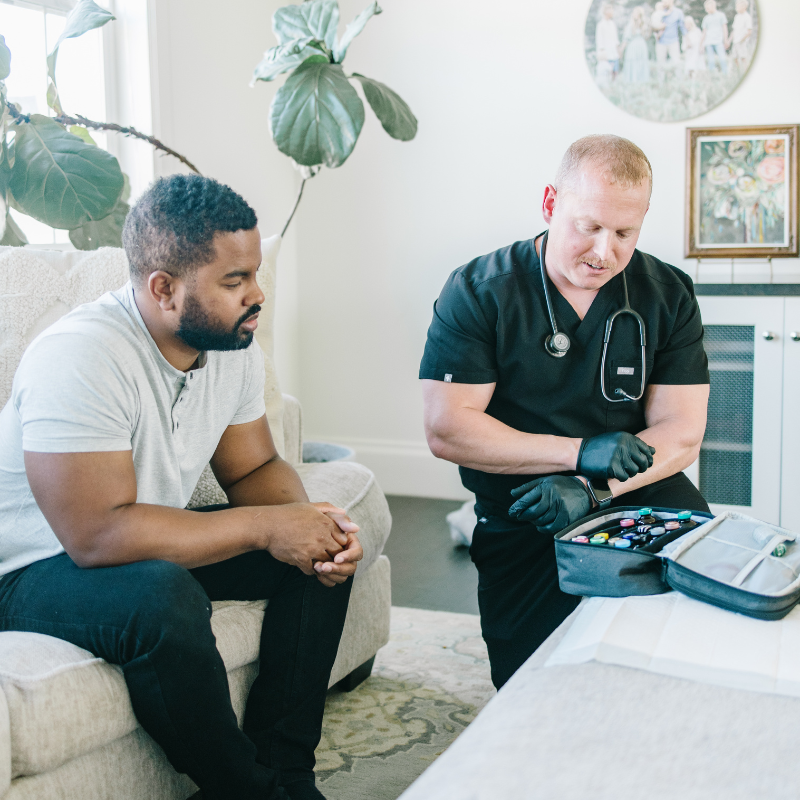 A man is sitting on a couch talking to a doctor