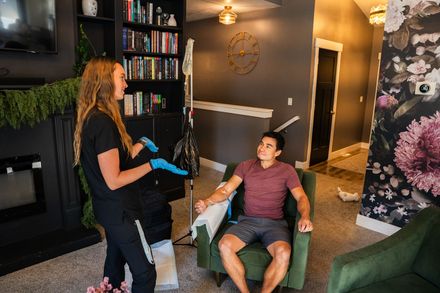 A man is talking on a cell phone while looking at his watch.