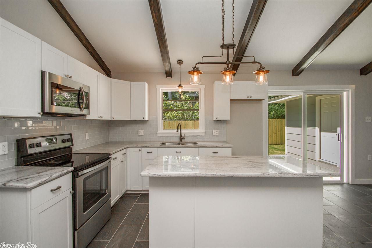 Modern bathroom with marble floors, stone walls, floating vanity, and walk-in shower.