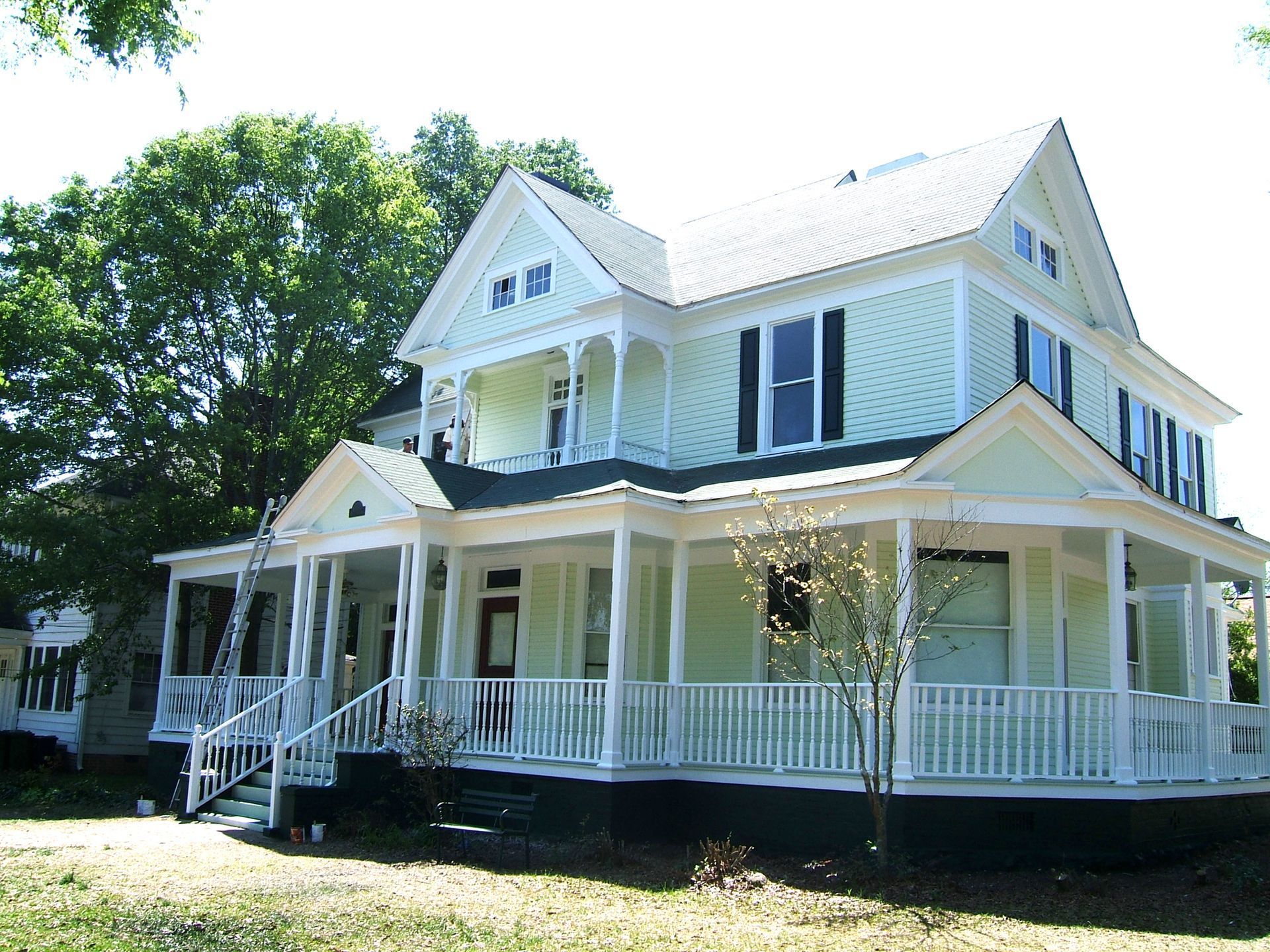 A large house with a large porch and stairs after painting of the house