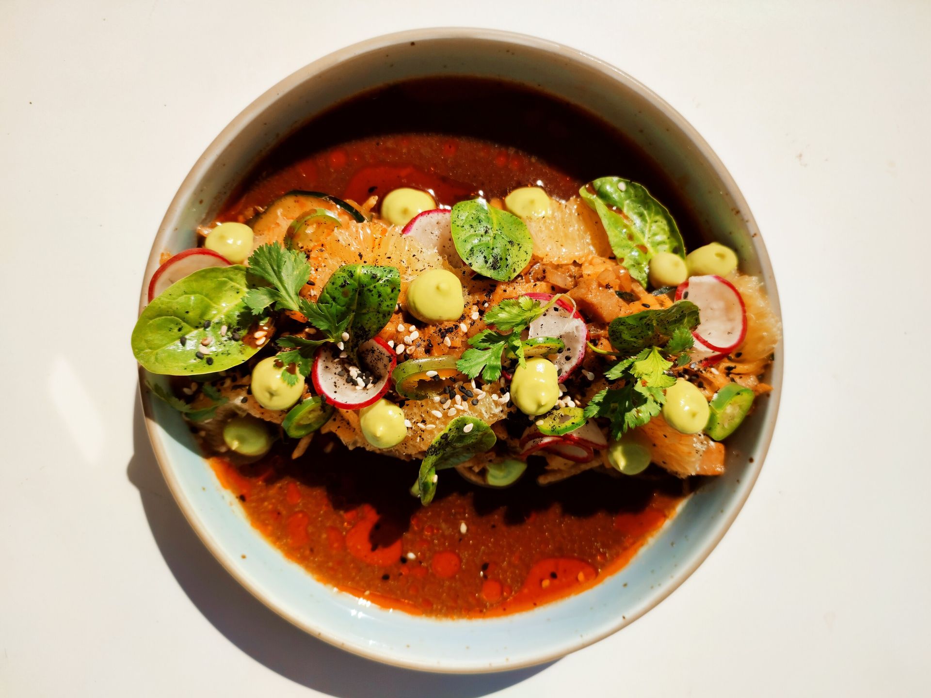 Un plato de comida con verduras y salsa sobre una mesa.