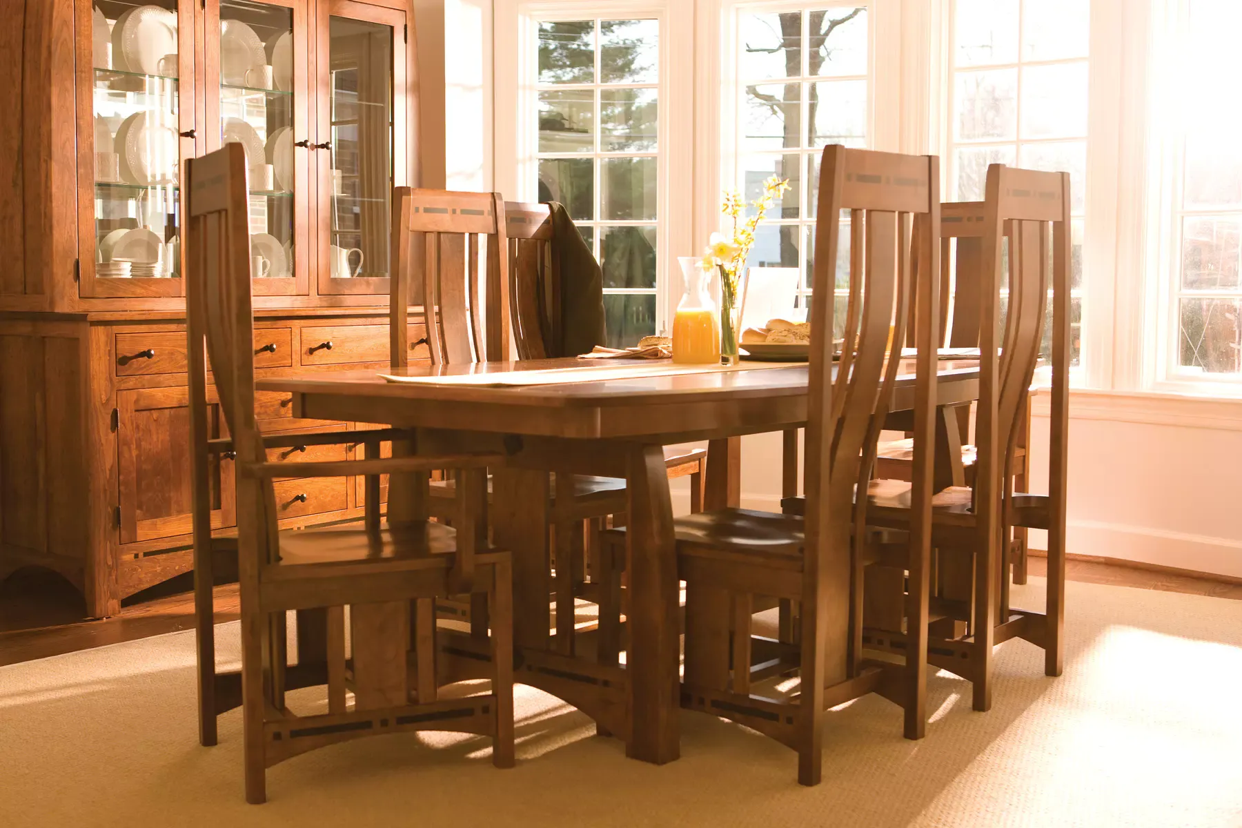 A dining room with a wooden table and chairs