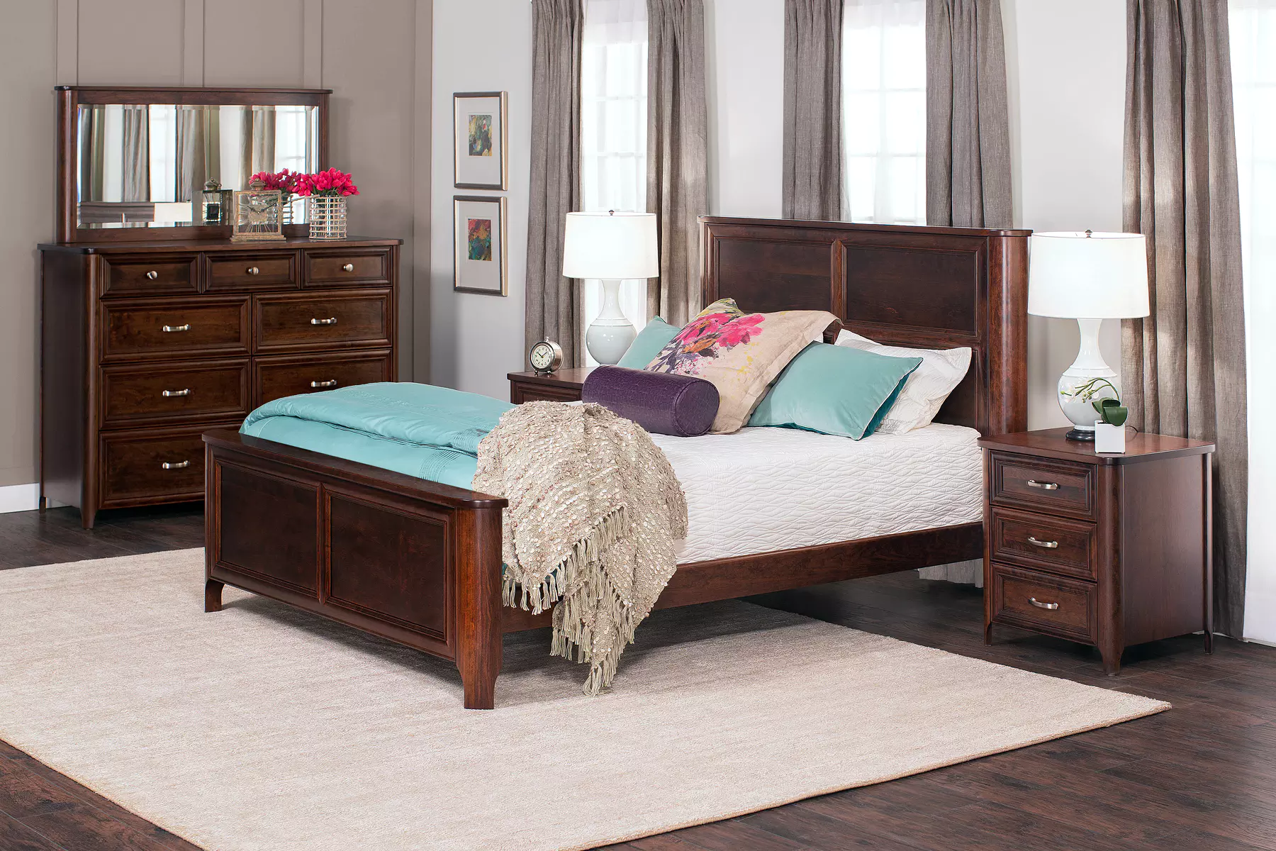 A bedroom with a bed , dresser , nightstand , mirror and rug.