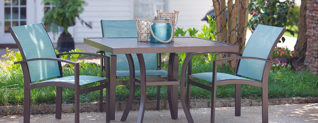 A table and chairs are sitting on a patio in front of a house.