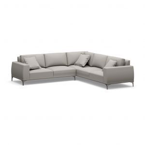 A grey sectional couch with pillows on a white background.