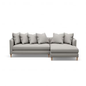 A grey sectional couch with pillows on a white background.