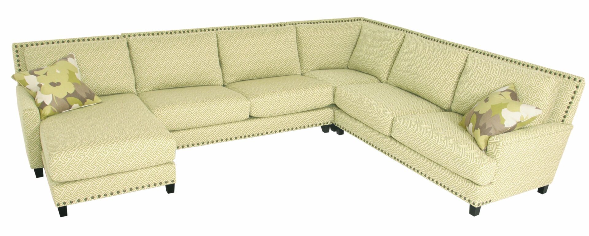 A large sectional couch with pillows on it is on a white background.