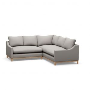 A grey sectional couch with wooden legs on a white background.