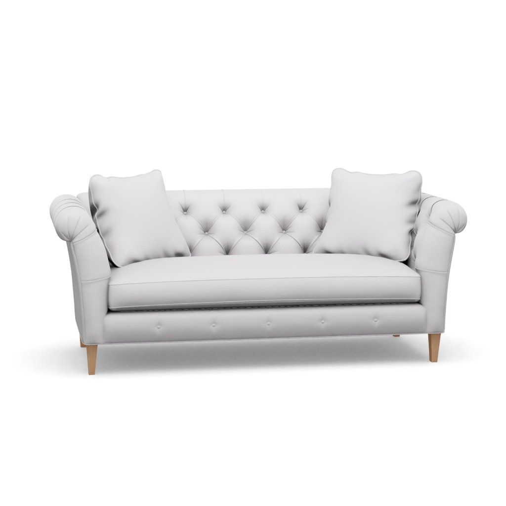A white couch with two pillows on it on a white background.