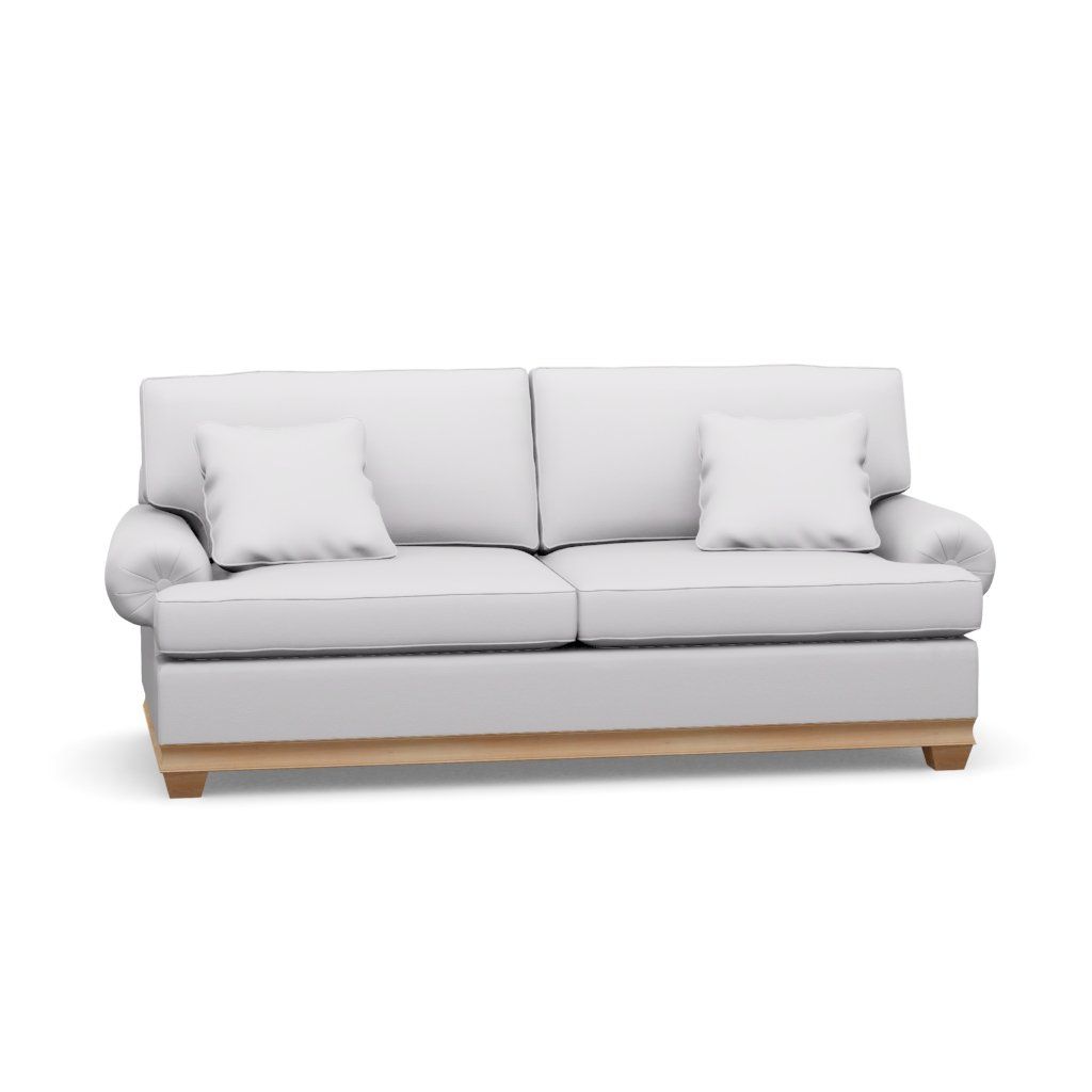 A white couch with wooden legs and pillows on a white background.