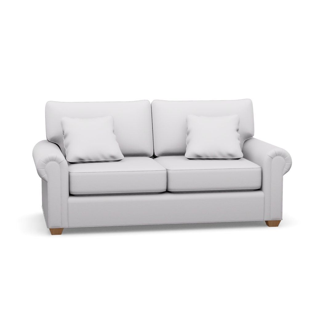 A white couch with two pillows on it on a white background.
