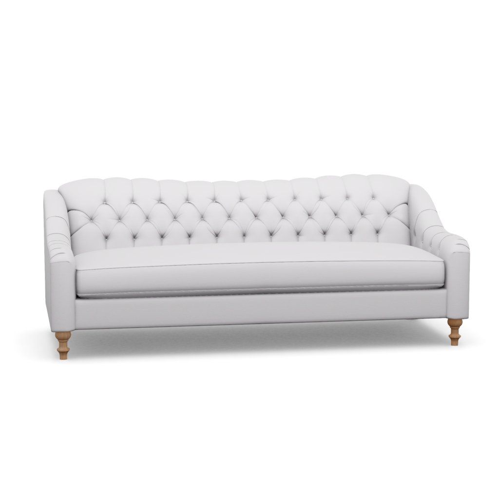 A white tufted couch with wooden legs on a white background.