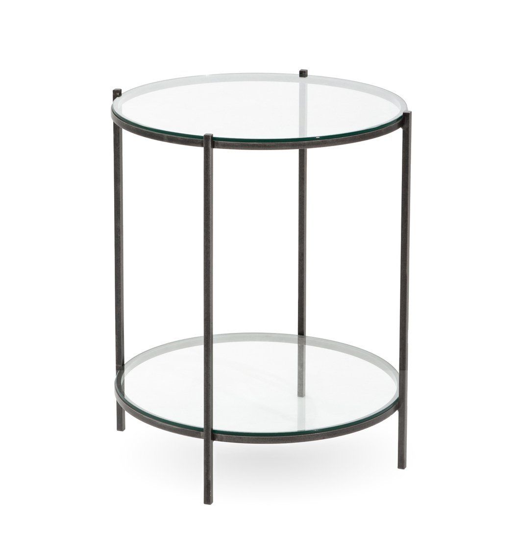 A small round table with a clear glass top and a black metal frame.