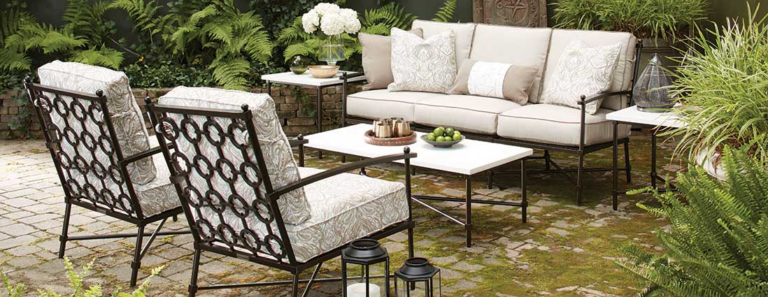 A patio with a couch , chairs , and a table.