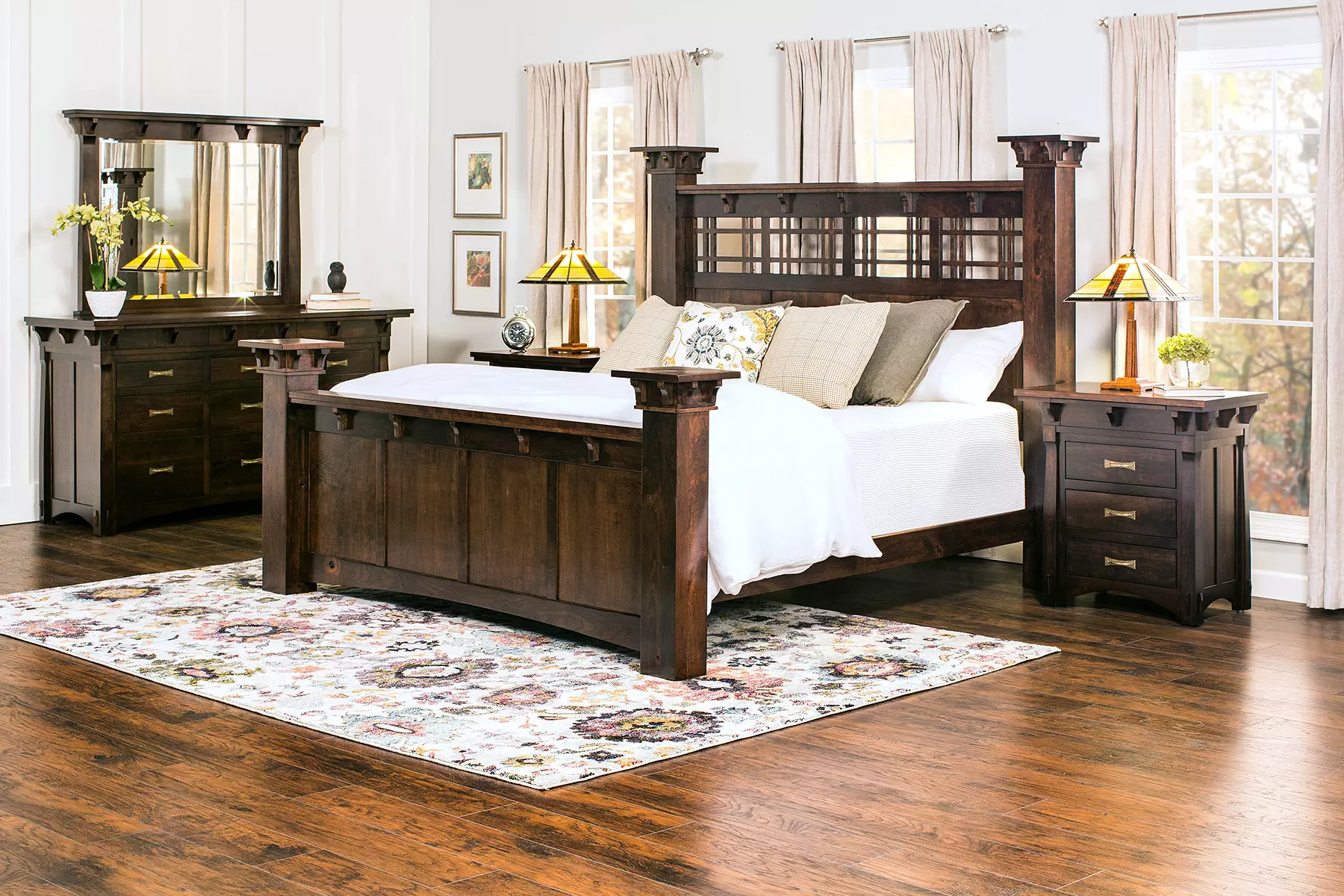 A bedroom with a bed , dresser , nightstand , mirror and rug.