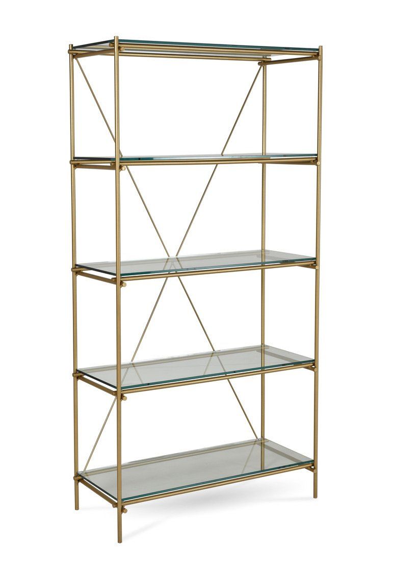 A brass bookshelf with glass shelves on a white background