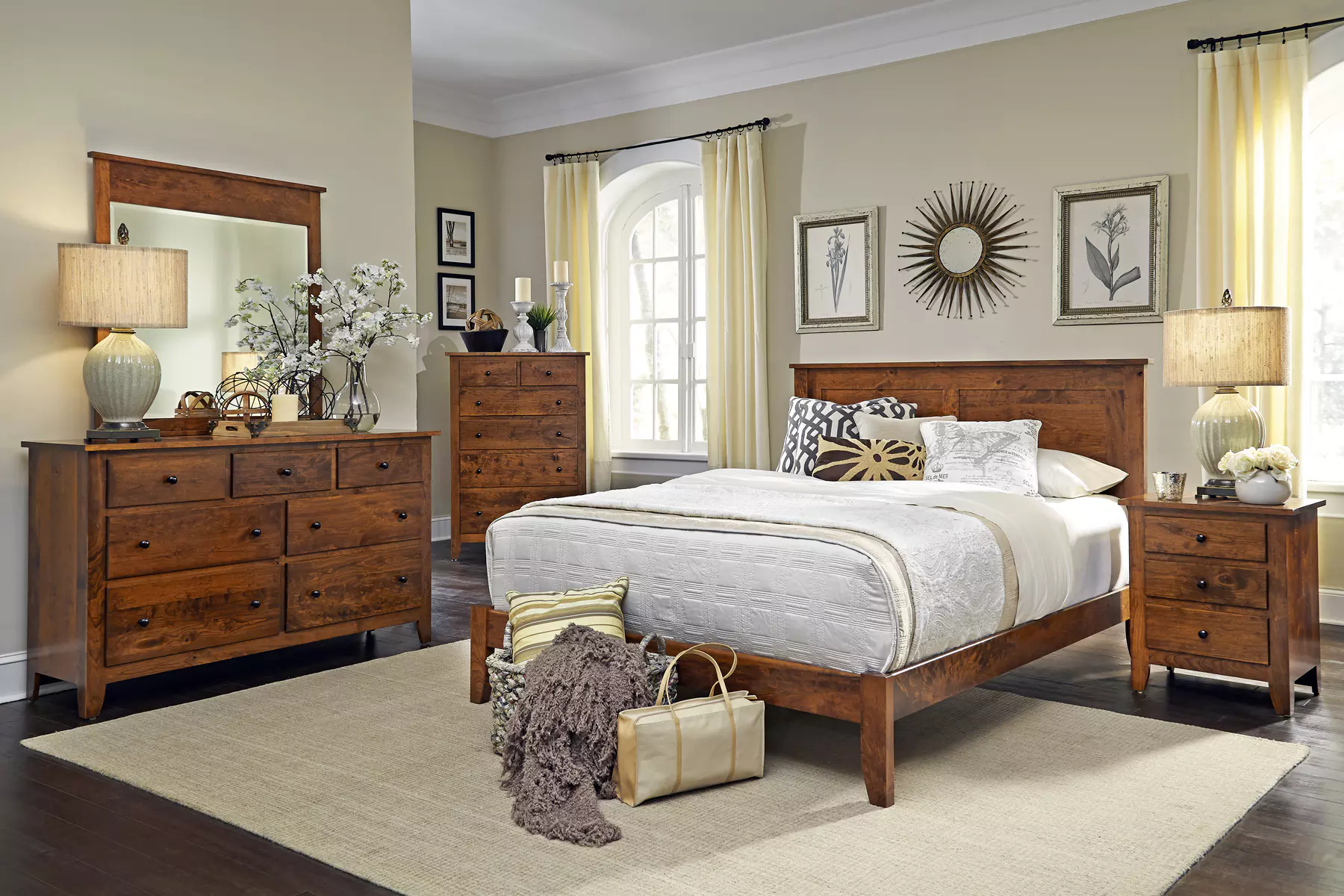A bedroom with a bed , dresser , nightstand , mirror and rug.