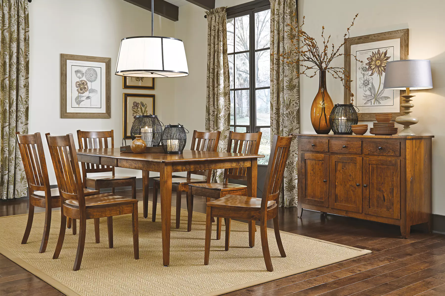 A dining room with a table and chairs and a dresser.
