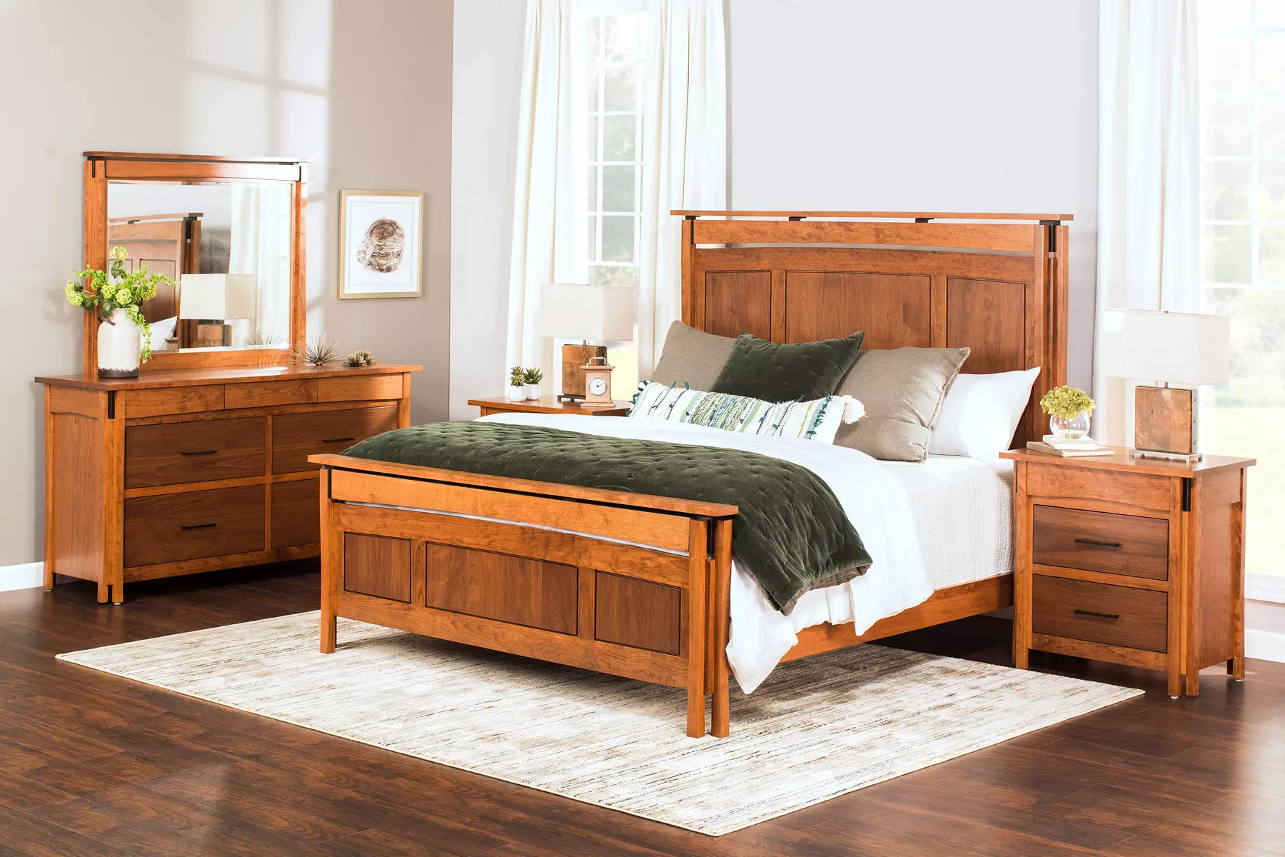 A bedroom with a bed , dresser , nightstand , mirror and rug.