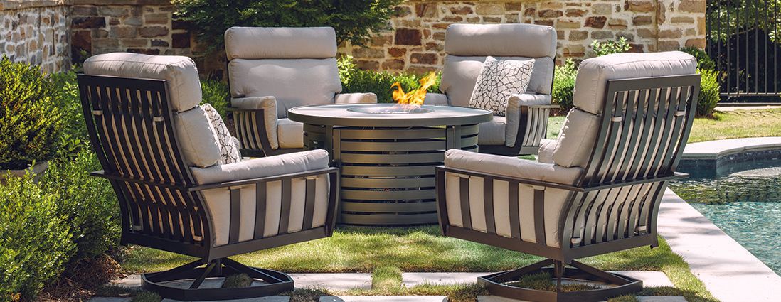 A patio set with chairs and a table next to a pool.