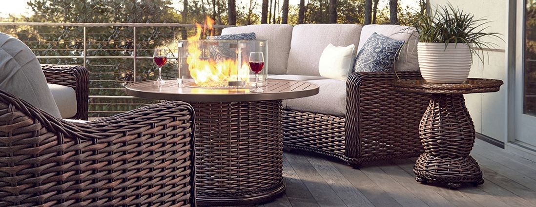 A patio with wicker furniture and a fire pit.