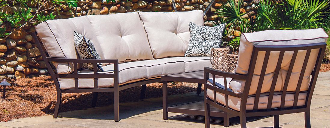 A couch and two chairs are sitting on a patio.
