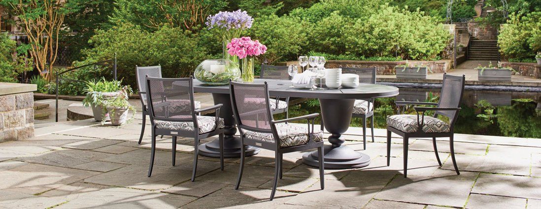 A table and chairs are sitting on a patio next to a pond.