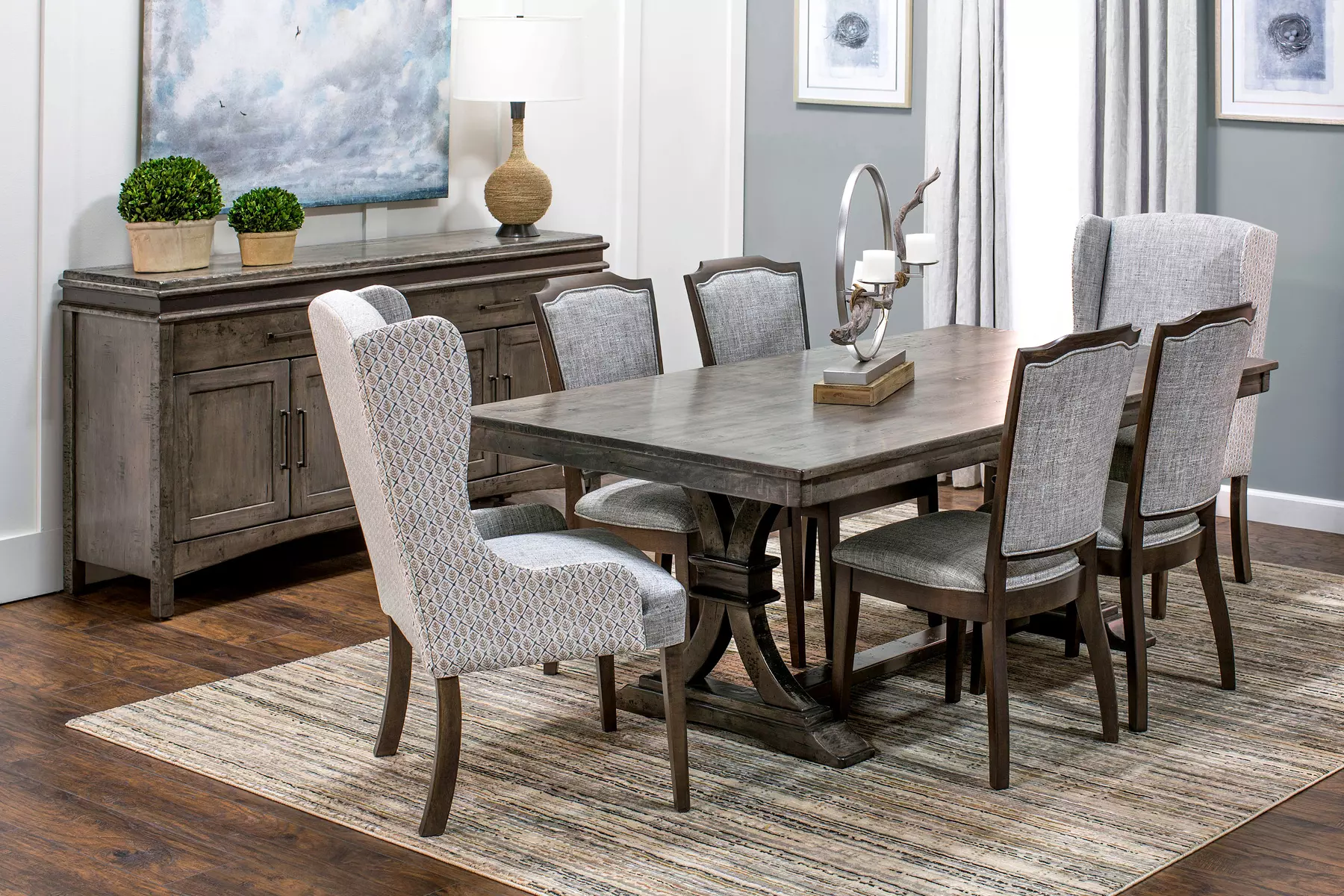 A dining room with a table and chairs and a rug.