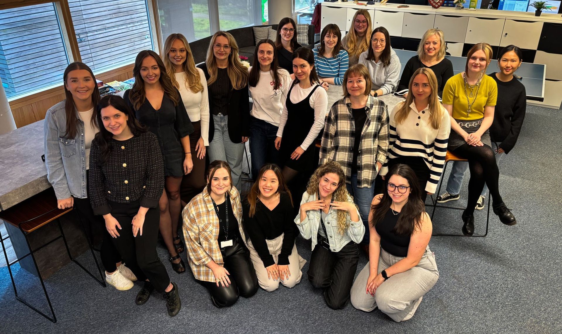 A group of women are posing for a picture in an office.
