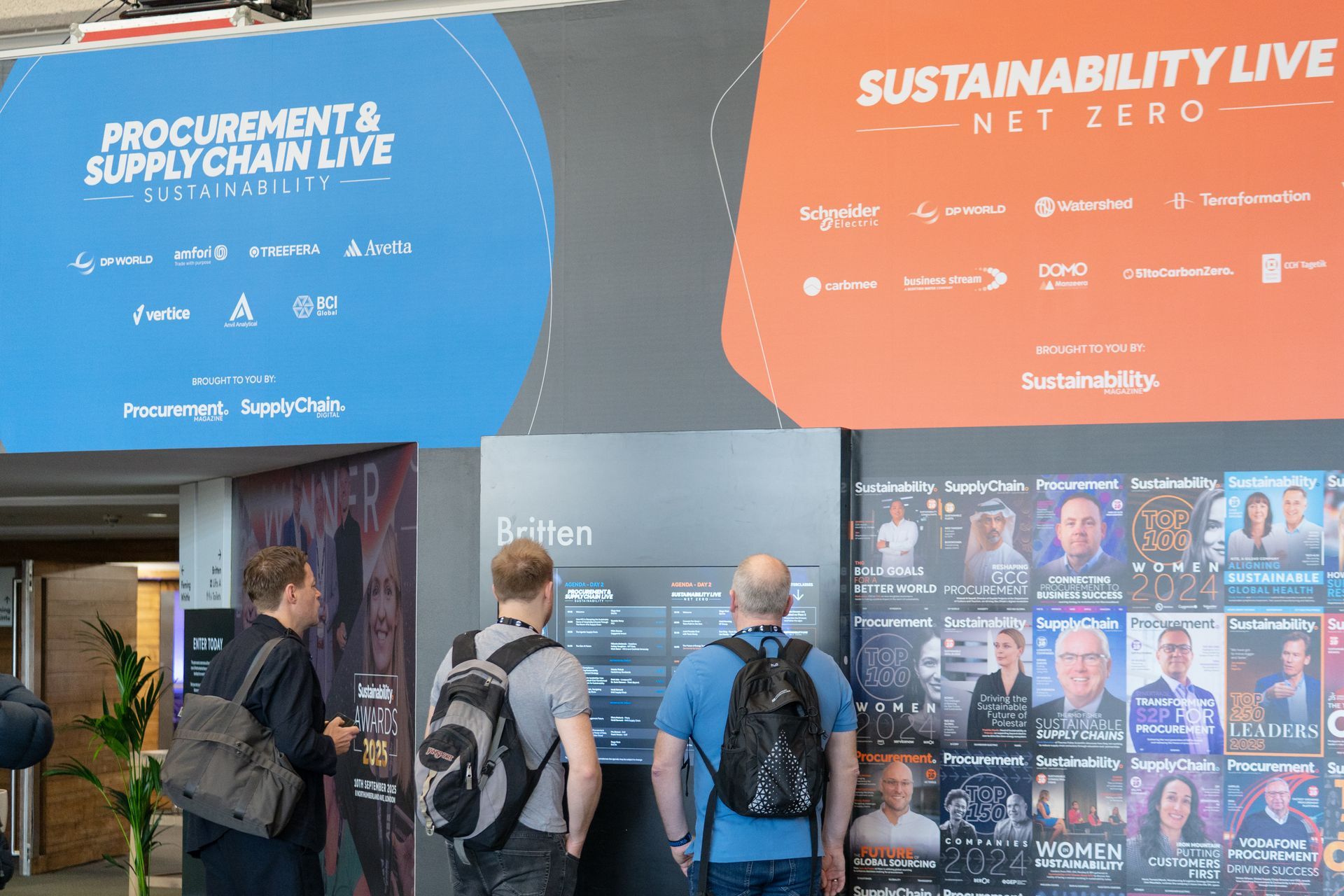A group of people are standing in front of a sign that says procurement and supply chain live.