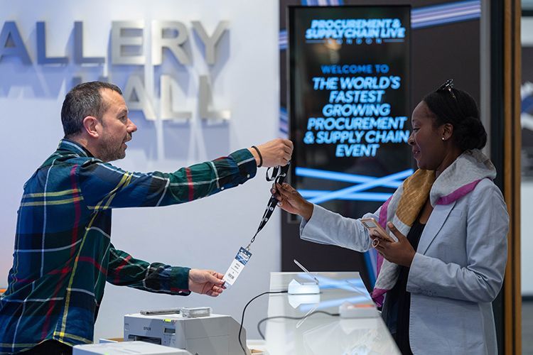 A man is giving a badge to a woman at a counter.