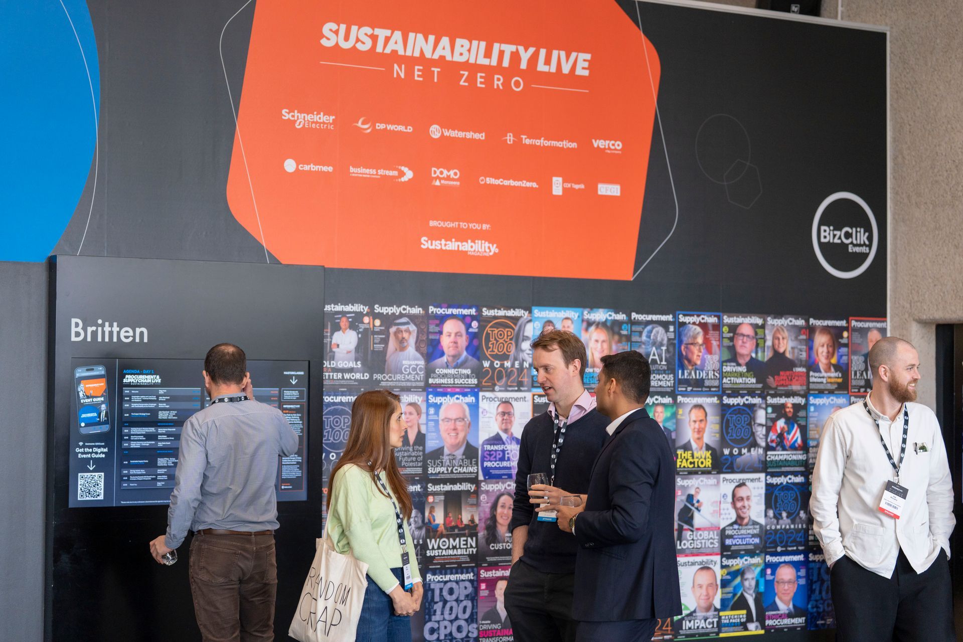 A group of people standing in front of a sign that says sustainability live