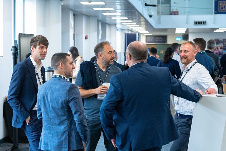 A group of men are standing in a hallway talking to each other.