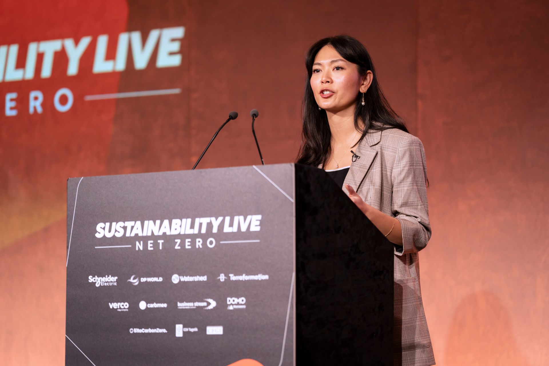 A woman is giving a speech at sustainability live net zero