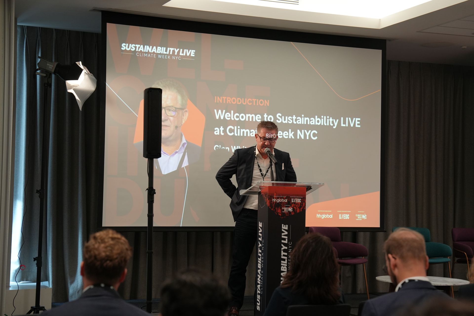A man is giving a presentation in front of a large screen.