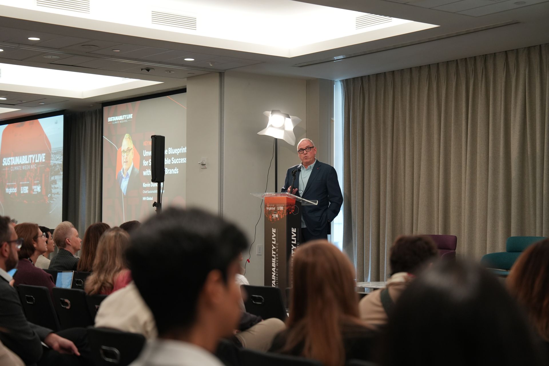 A man is standing at a podium giving a presentation to a group of people.