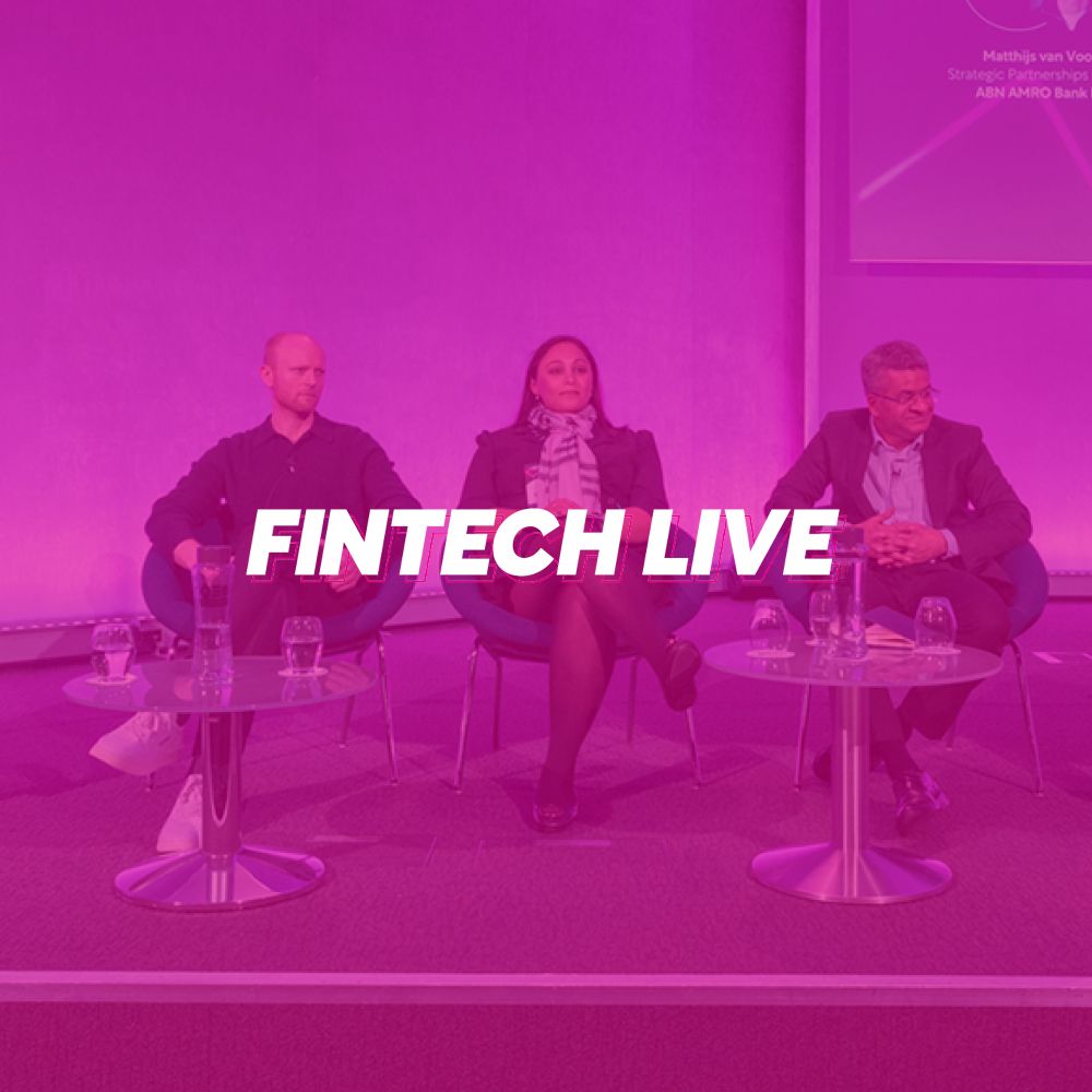 A group of people are sitting at tables in front of a purple background.