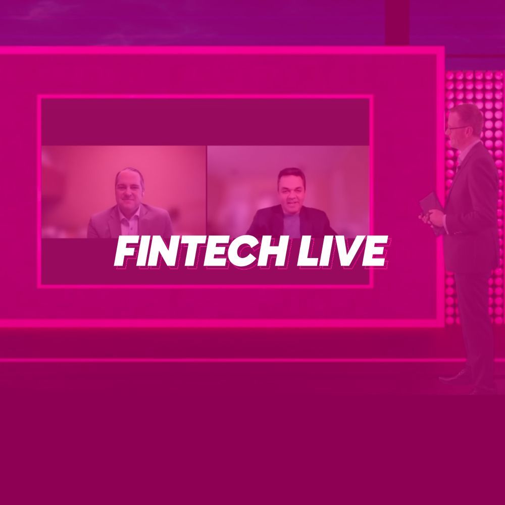 A man is standing in front of a pink screen that says fintech live.