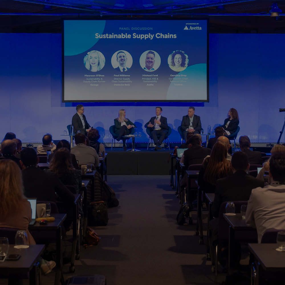 A group of people are sitting in front of a screen that says assent